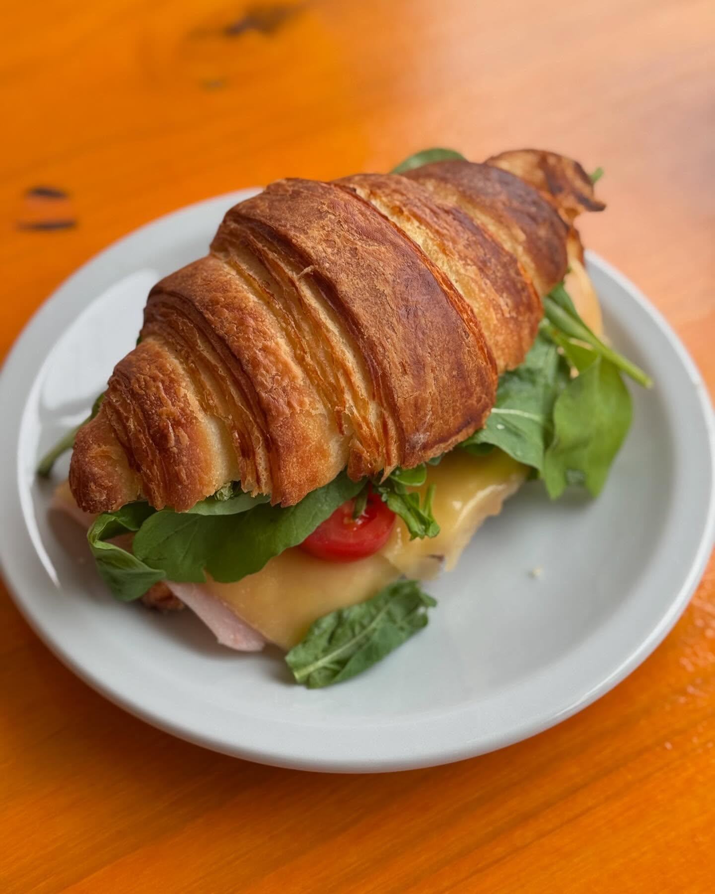 Desayuno con croissants, café latte art en corazón y jugo de naranja