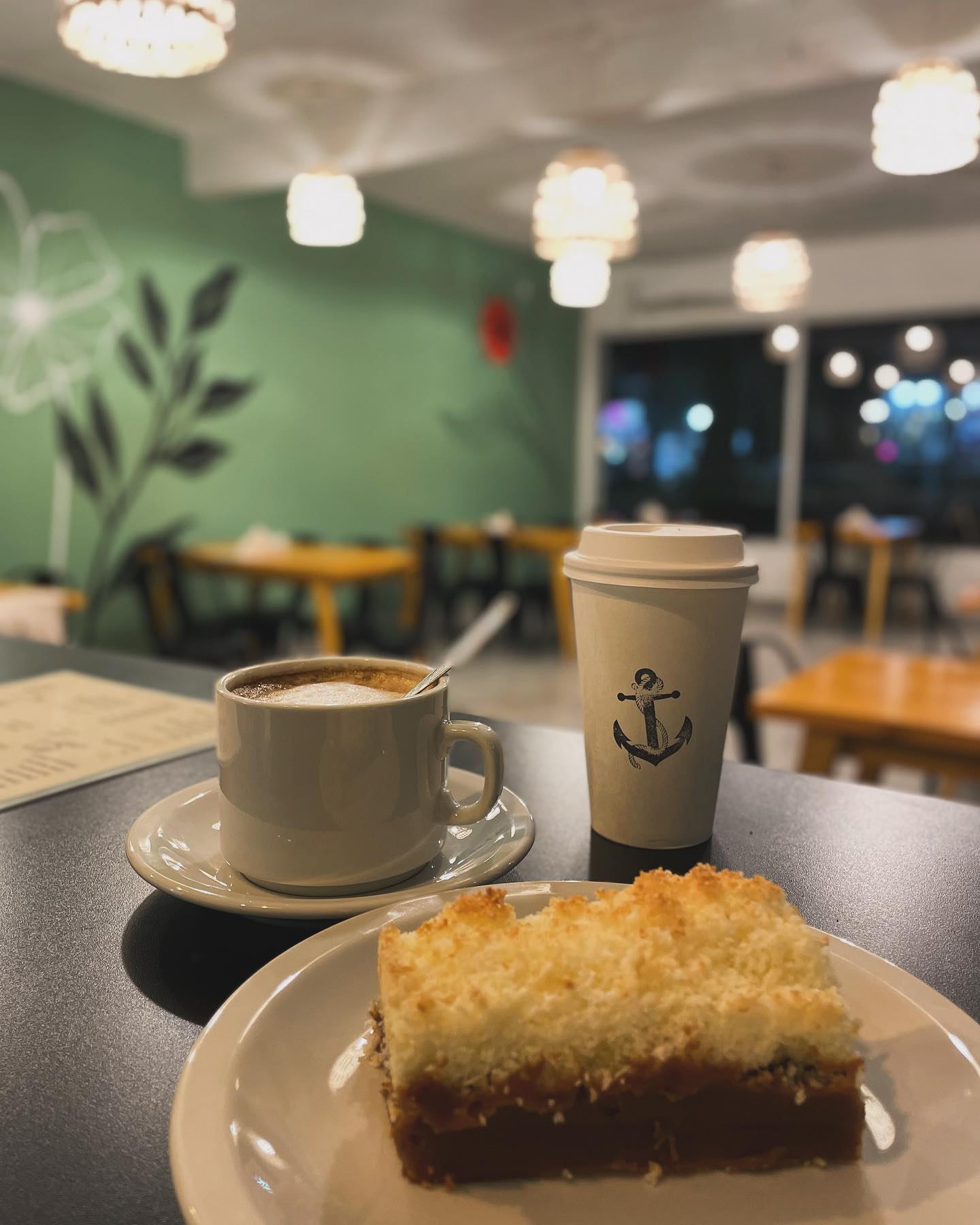 Interior de Salvatto Coffee en Ostende, Pinamar — paredes verde salvia, café y postre casero